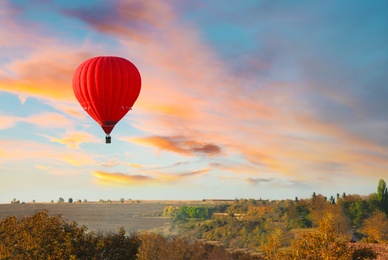 Colorful hot air balloon flying over countryside. Space for text