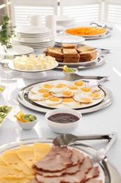 Different meals for breakfast on white table indoors. Buffet service