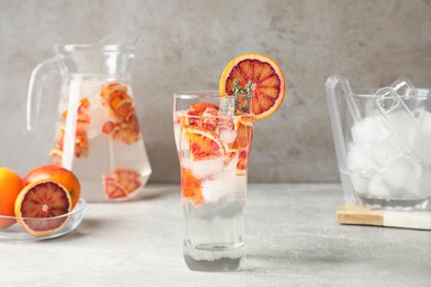 Delicious refreshing drink with sicilian orange on light grey table
