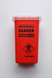 Sharps container for used syringe on white background, top view