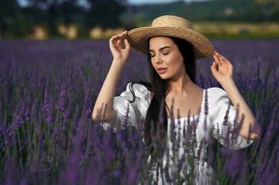 Photo of Beautiful young woman with straw hat in lavender field