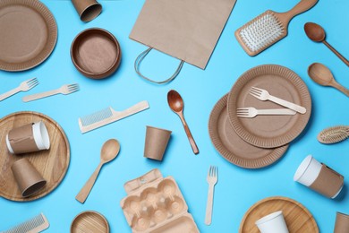 Different eco items on light blue background, flat lay. Recycling concept