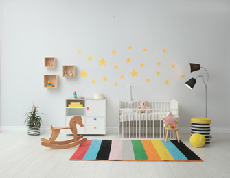 Stylish baby room interior with crib and toys