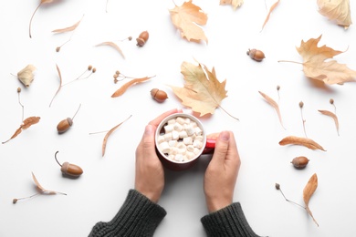 Woman holding hot drink on white background, top view. Cozy autumn