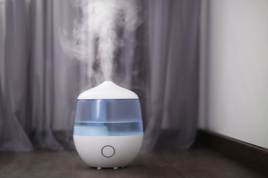 Modern air humidifier on floor at home