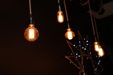 Glowing lamp bulbs in dark room. Interior element