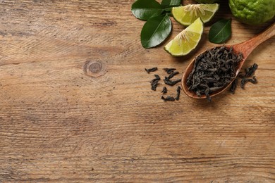 Dry bergamot tea leaves and fresh fruits on wooden table, flat lay. Space for text