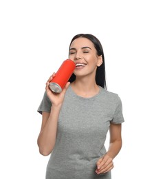 Beautiful happy woman drinking from red beverage can on white background