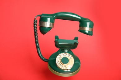 Green vintage corded phone on red background