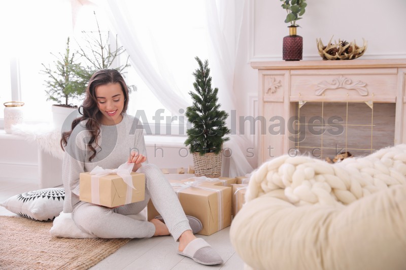Woman with gift box on floor at home
