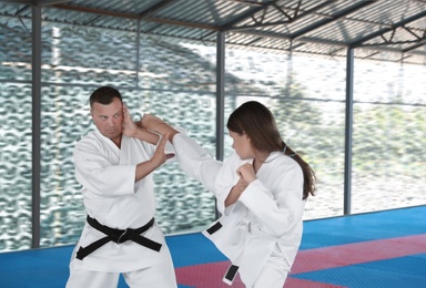 CHERNOMORKA, UKRAINE - JULY 10, 2020: Little girl with instructor practicing karate on training ground
