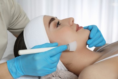 Young woman during face peeling procedure in salon