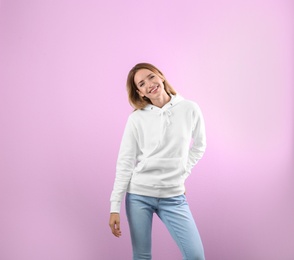 Photo of Portrait of woman in hoodie sweater on color background. Space for design