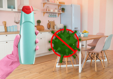 Image of Keep your home virus-free. Woman holding bottle of disinfecting solution in kitchen