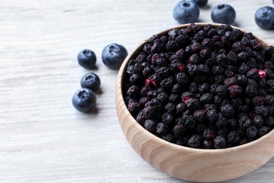 Freeze dried and fresh blueberries on white wooden table, closeup. Space for text