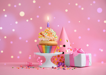 Composition with birthday cupcake on pink background. Bokeh effect