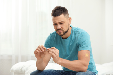 Man with nicotine patch and cigarette in bedroom