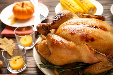 Traditional Thanksgiving day feast with delicious cooked turkey and other seasonal dishes served on wooden table, closeup