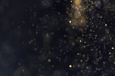 Golden glitter with bokeh effect on dark background