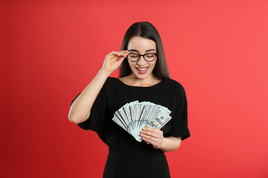 Young woman with money on crimson background