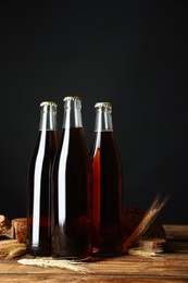 Bottles of delicious fresh kvass, spikelets and bread on wooden table