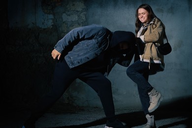 Photo of Woman defending herself from attacker outdoors at night