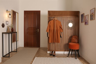 Photo of Modern hallway interior with stylish furniture and clothes rack