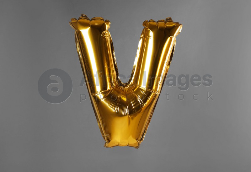 Photo of Golden letter V balloon on grey background