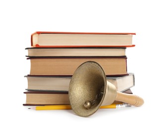 Golden school bell with wooden handle, pencils and stack of books on white background