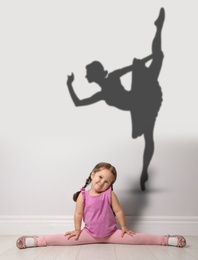 Cute little girl dreaming to be ballet dancer. Silhouette of woman behind kid's back