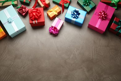 Many colorful gift boxes on grey table, above view. Space for text