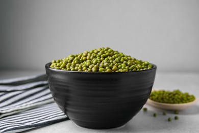 Bowl with green mung beans on grey table, closeup