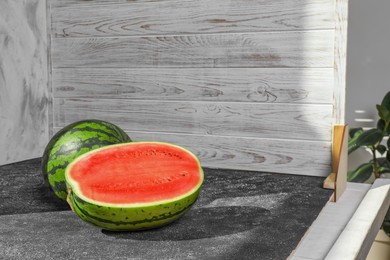 Fresh juicy watermelon and double-sided backdrops on table in photo studio. Space for text