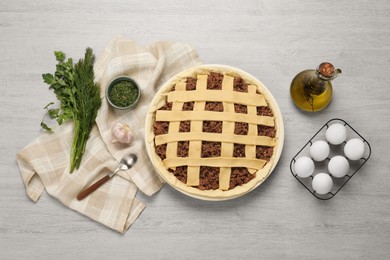 Photo of Raw meat pie and ingredients on white wooden table, flat lay