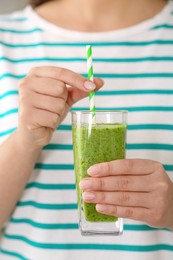 Photo of Woman holding glass with delicious smoothie, closeup