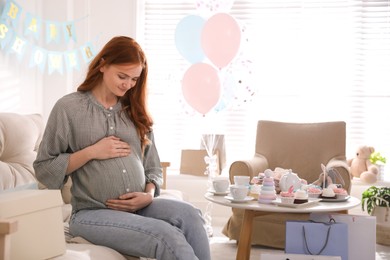 Happy pregnant woman in room decorated for baby shower party