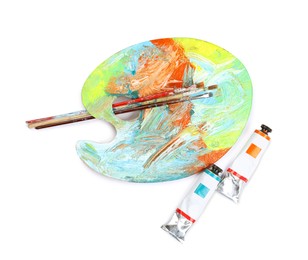 Dirty artist's palette with brushes and tubes of paint on white background