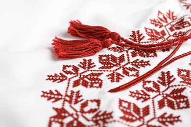 Beautiful red Ukrainian national embroidery on white fabric, closeup