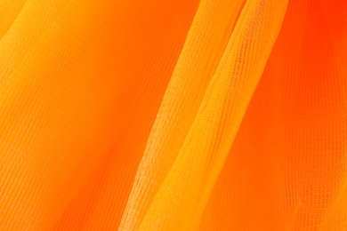 Texture of orange tulle as background, closeup