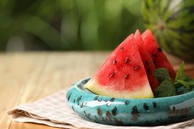 Slices of delicious ripe watermelon on wooden table outdoors, closeup. Space for text