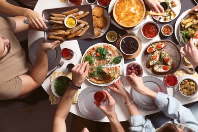 Group of people having brunch together at table indoors, top view