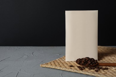 Scented sachet and coffee beans on grey table against black background, space for text