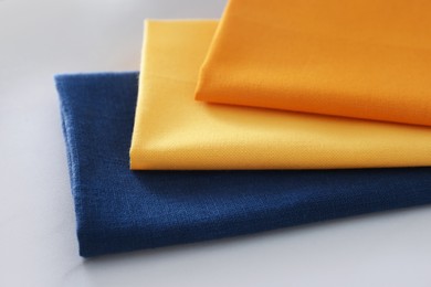Different colorful napkins on white table, closeup