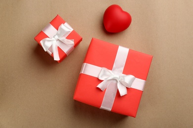 Beautiful gift boxes and red heart on brown background, flat lay. Valentine's day celebration