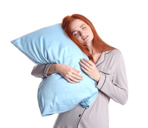 Young woman wearing pajamas with pillow in sleepwalking state on white background