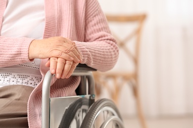 Handicapped elderly woman in nursing home, closeup with space for text. Assisting senior generation