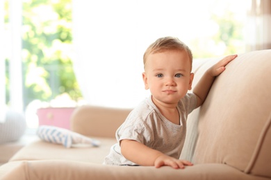 Photo of Adorable little baby on sofa at home