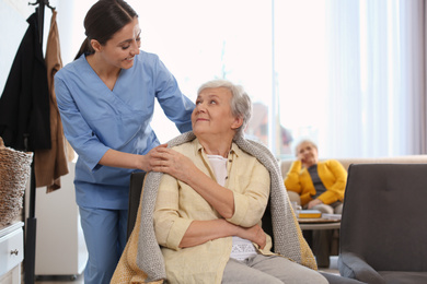 Nurse taking care of elderly woman in geriatric hospice