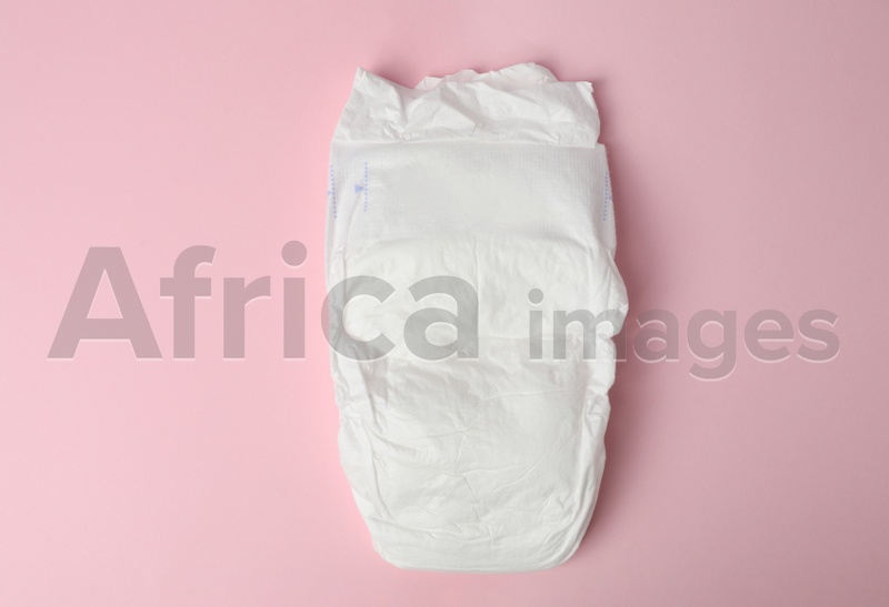 Baby diaper on pink background, top view