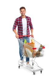 Young man with full shopping cart on white background